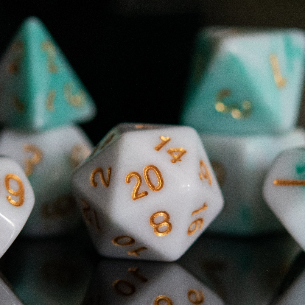A set of seafoam green and white acrylic dice with engraved numbers, reflecting on a black surface.