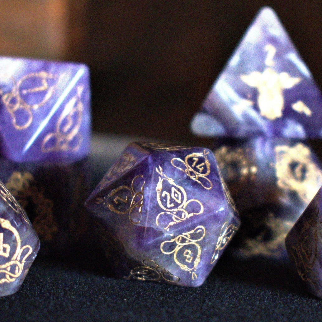 A set of viking inspired purple amethyst stone ttrpg dice with engraved numbers in gold