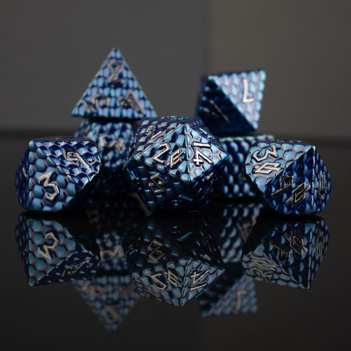A set of blue dragon scale textured dnd metal dice with silver numbering 