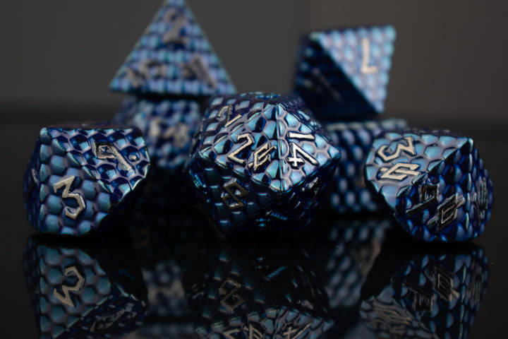 A set of blue dragon scale textured dnd metal dice with silver numbering 