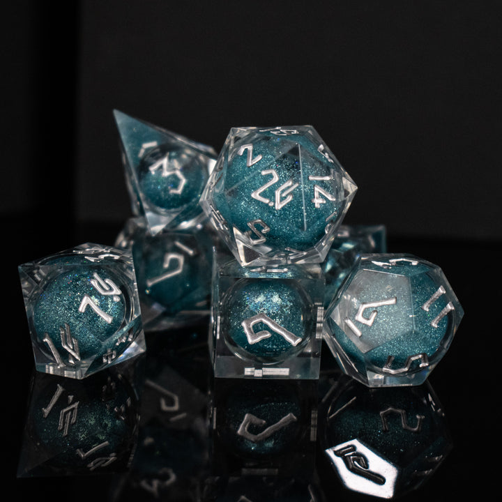 A set of hand-crafted resin dice with blue liquid core and hand-painted numbers, including various shapes such as a d4, d6, d8, d10, d12, and d20.