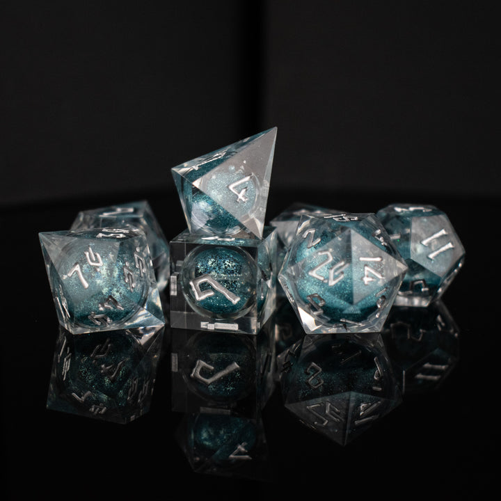 A set of hand-crafted resin dice with blue liquid core and hand-painted numbers, including various shapes such as a d4, d6, d8, d10, d12, and d20.