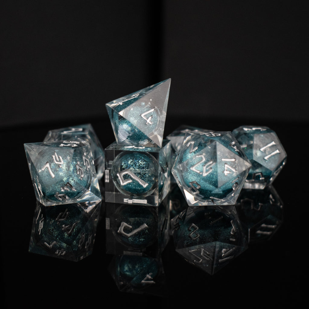 A set of hand-crafted resin dice with blue liquid core and hand-painted numbers, including various shapes such as a d4, d6, d8, d10, d12, and d20.