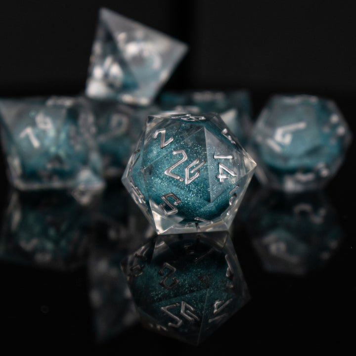 A set of hand-crafted resin dice with blue liquid core and hand-painted numbers, including various shapes such as a d4, d6, d8, d10, d12, and d20.