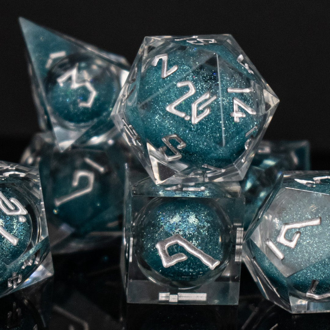 Set of teal polyhedral dice with silver numbers on a reflective black surface