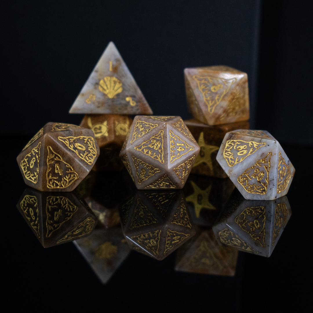 A set of hand-carved, fossil coral dice with engraved numbers, displayed on a reflective surface.