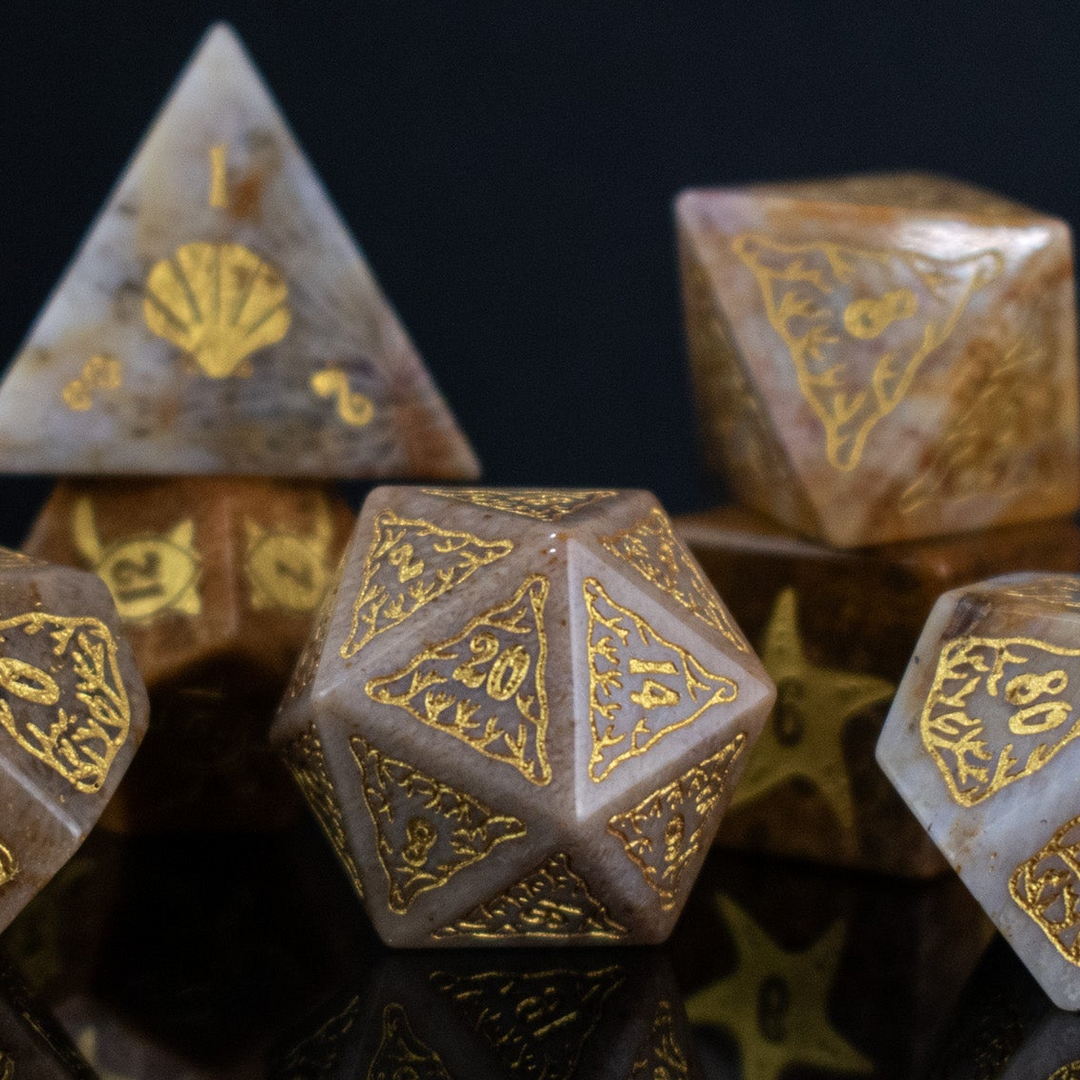 A set of hand-carved, fossil coral dice with engraved numbers, displayed on a reflective surface.