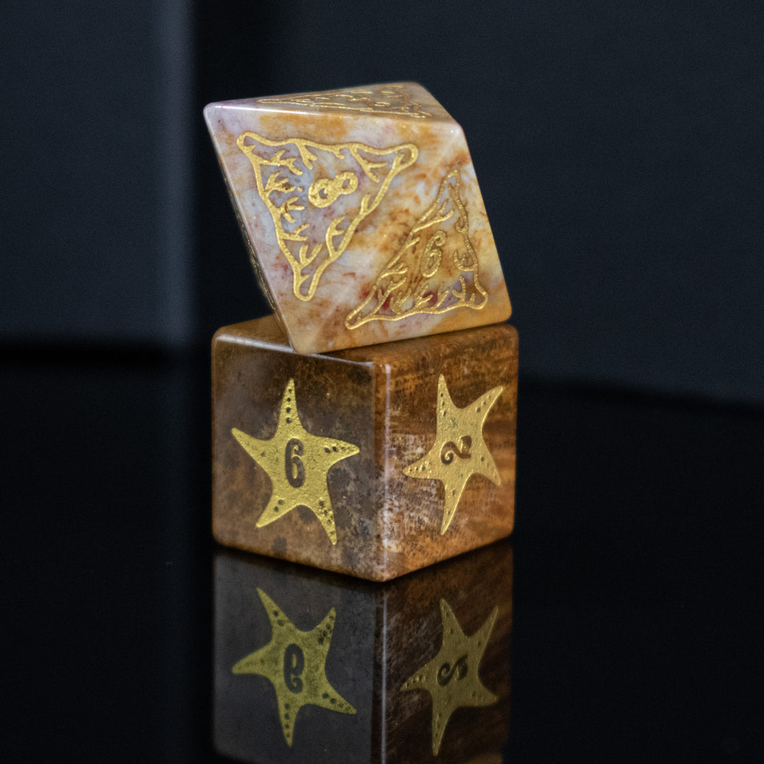 A set of hand-carved, fossil coral dice with engraved numbers, displayed on a reflective surface.
