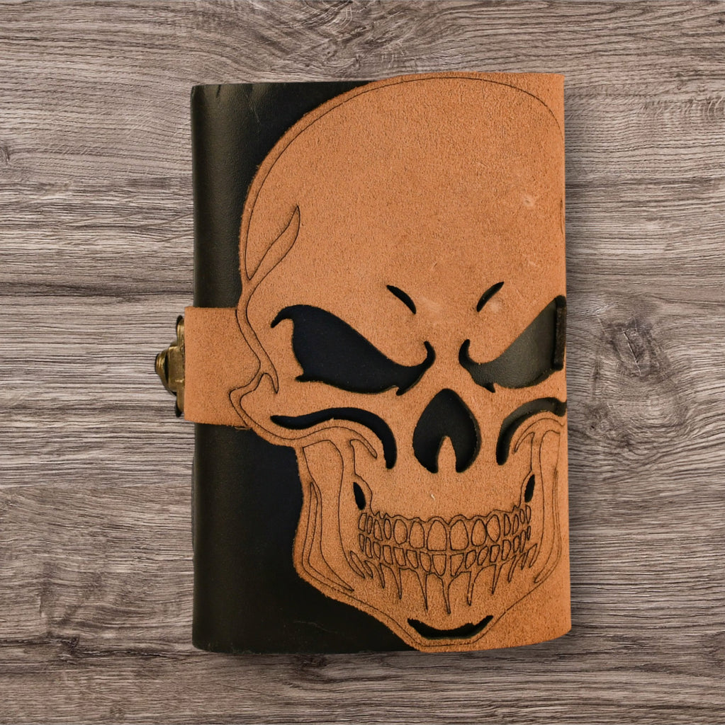 A leatherbound adventure journal with a skull design on the cover, featuring a brass buckle.