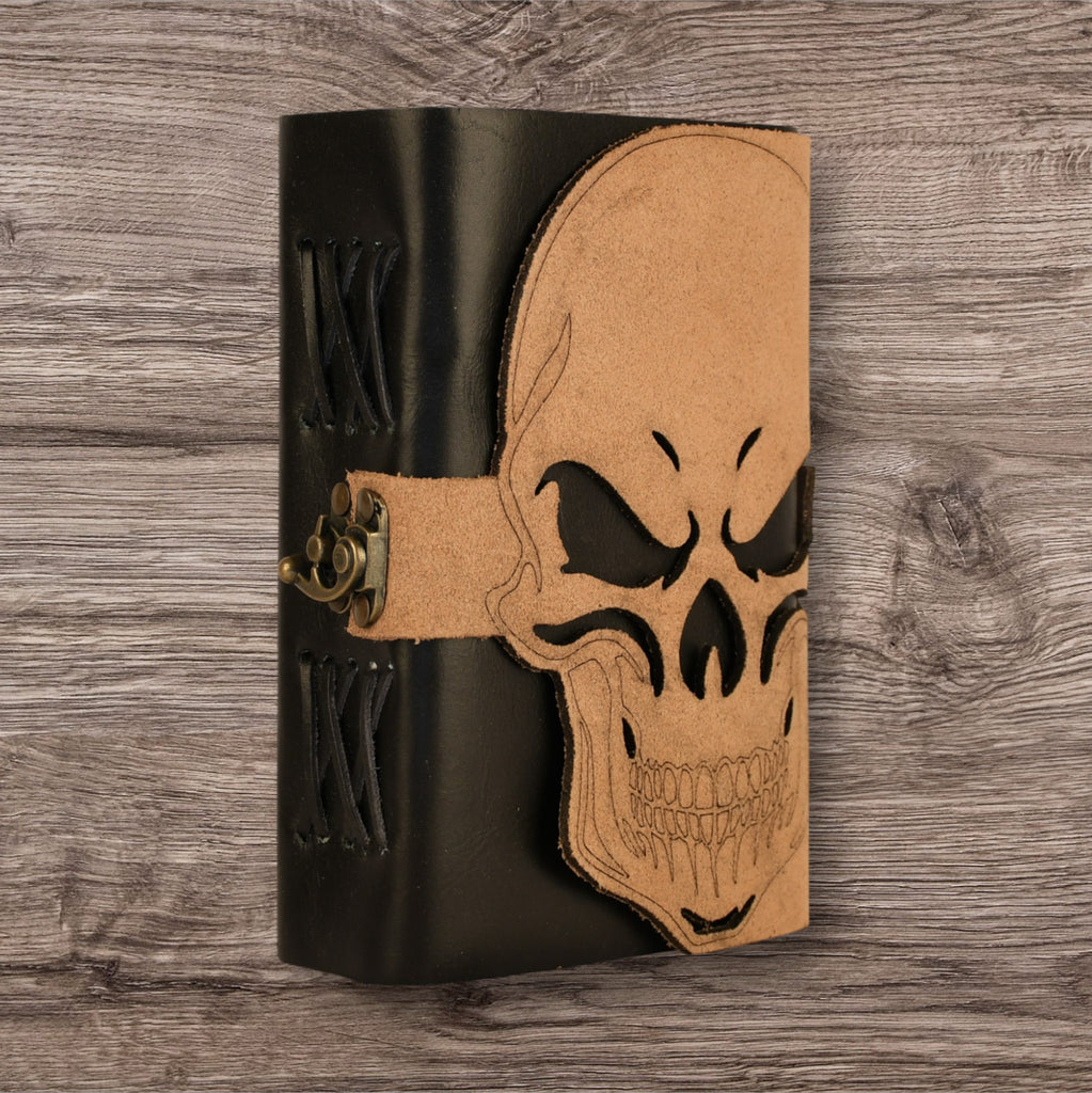 A leatherbound adventure journal with a skull design on the cover, featuring a brass buckle.