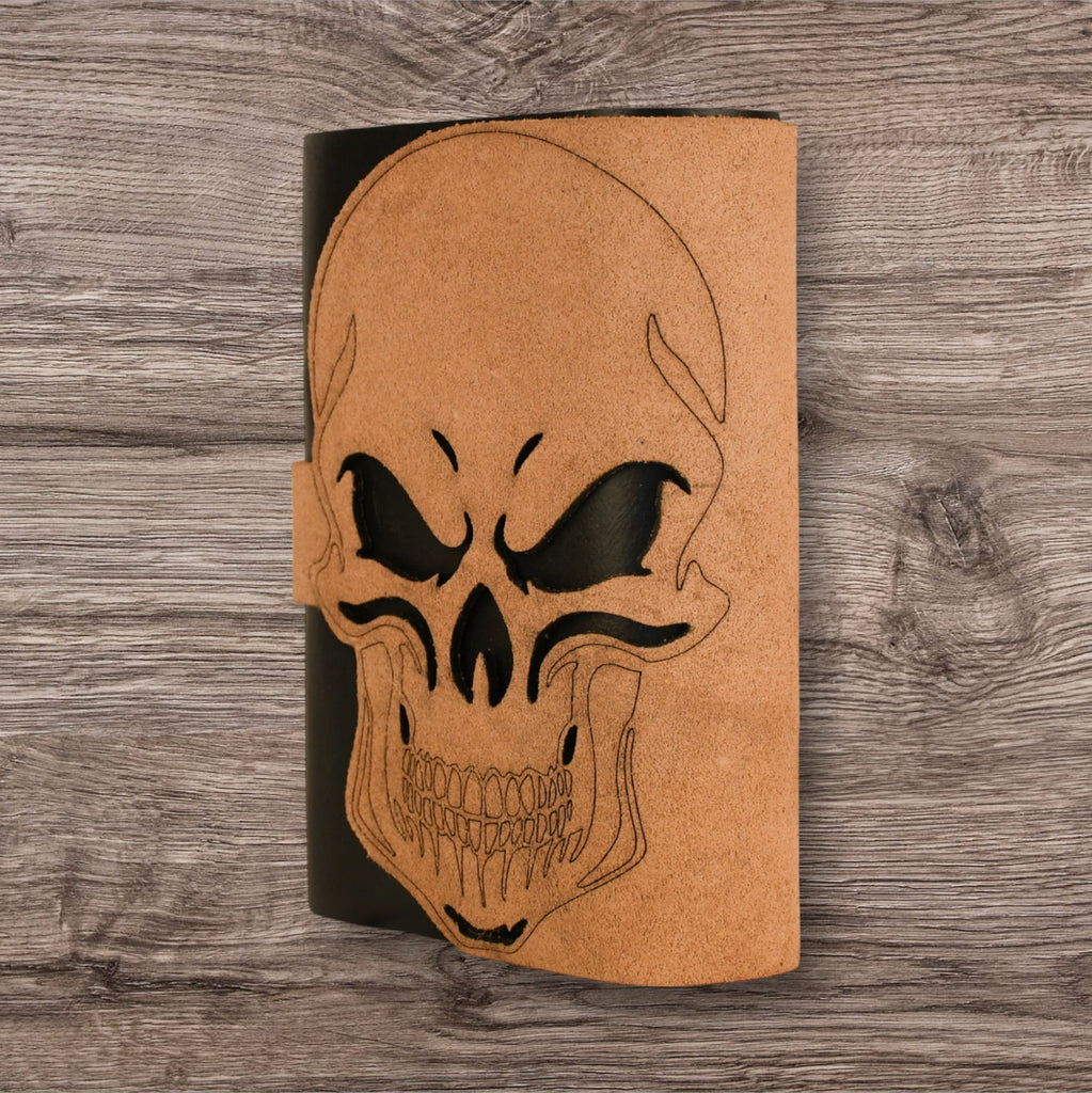 A leatherbound adventure journal with a skull design on the cover, featuring a brass buckle.