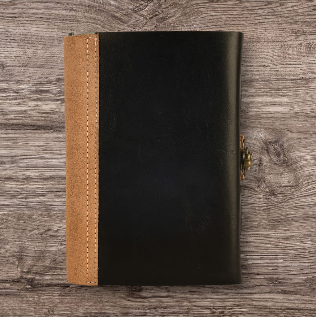 A leatherbound adventure journal with a skull design on the cover, featuring a brass buckle.