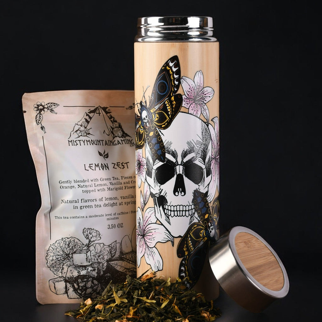 A stainless steel tea thermos with a graphic design of a skull, butterflies, and floral elements on the side. The thermos is accompanied by a removable steeper and is shown with the lid off.