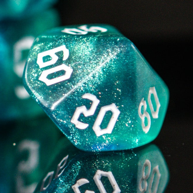 Close-up of a teal green polyhedral dice with numbers on a black background
