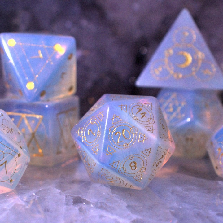 A set of hand-carved, Opalite gemstone dnd dice with engraved and golden hand-painted designs to create an iridescent spellcasting experience  