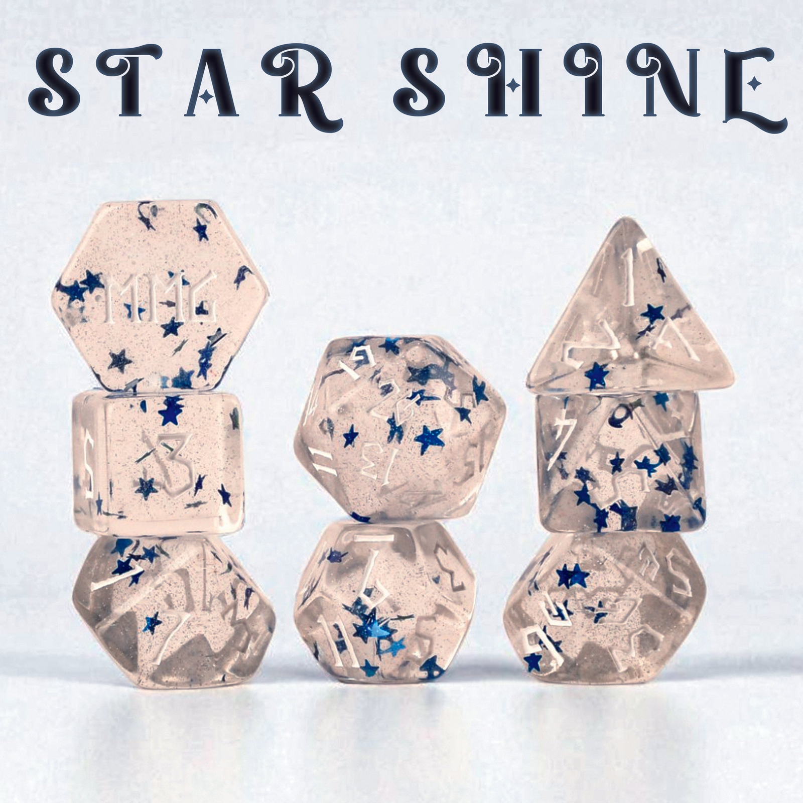Resin polyhedral dnd dice with blue stars inside of them, on a light blue background, featuring the brand 'Misty Mountain Gaming'.