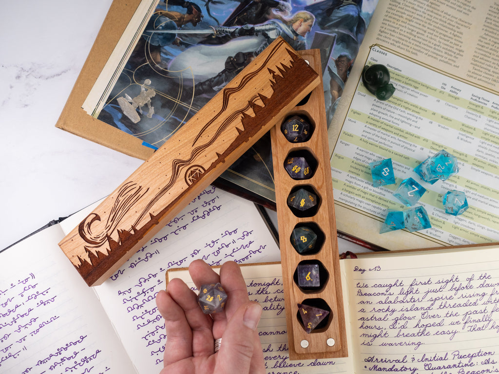 Wooden dice holder with engraved design on a table with gaming materials