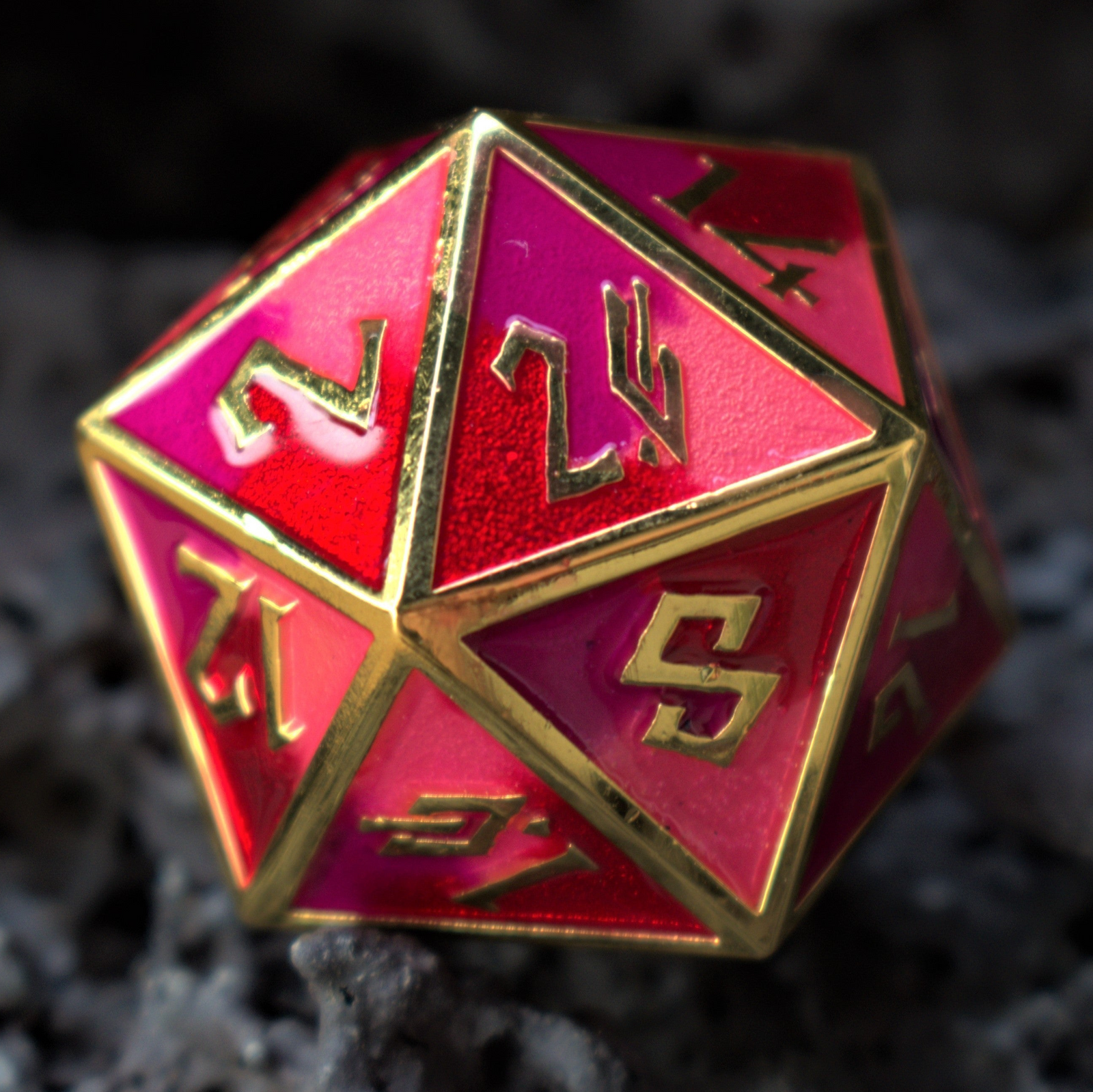 Red polyhedral dice with gold edges on a dark textured background