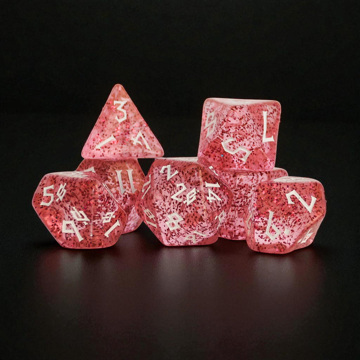 Pink acrylic dice set with glitter inside and white numbers in a clear nordic style font