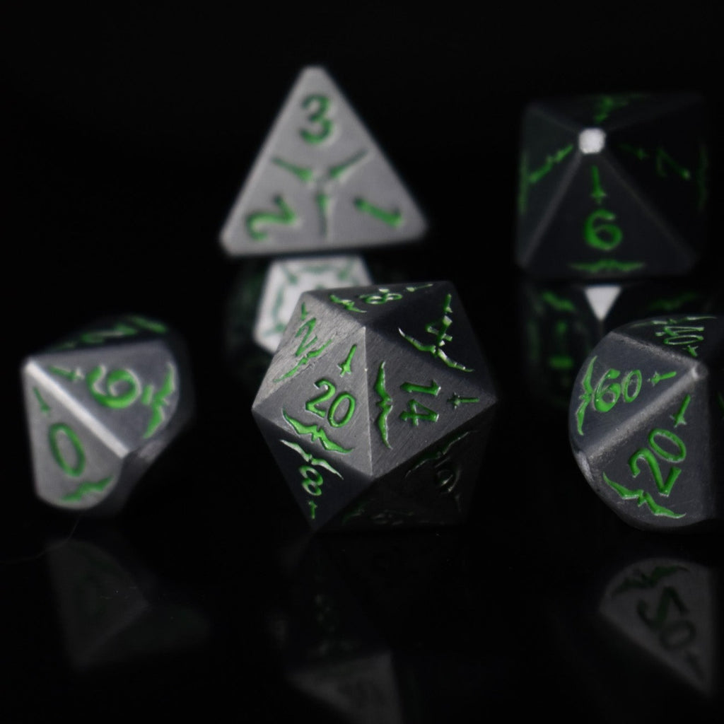A set of glow-in-the-dark metal dnd dice with engraved numbers and swords, including various shapes such as a d4, d6, d8, d10, d12, and d20, displayed on a black background.