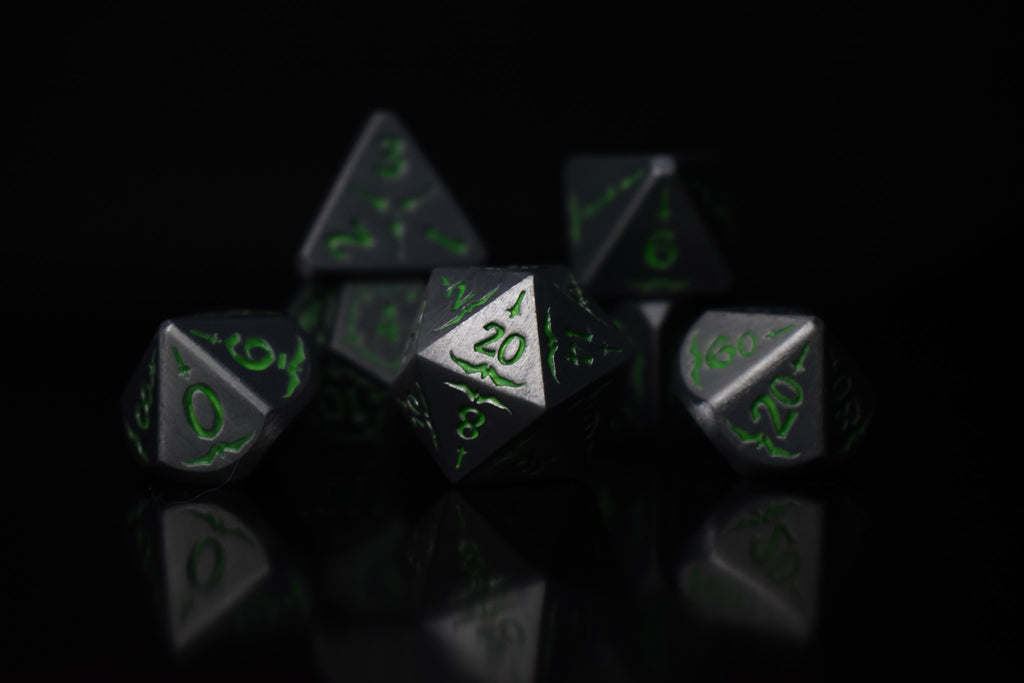 A set of glow-in-the-dark metal dnd dice with engraved numbers and swords, including various shapes such as a d4, d6, d8, d10, d12, and d20, displayed on a black background.