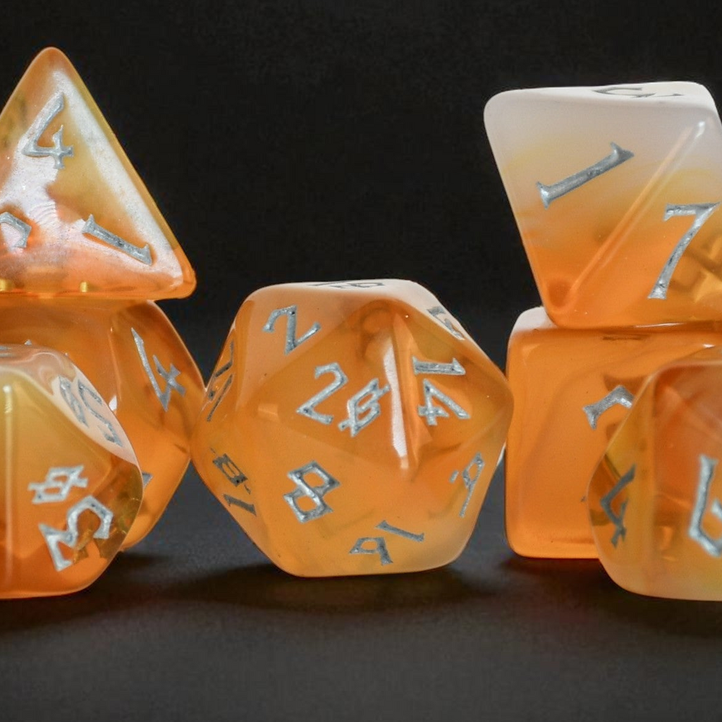 Set of orange polyhedral dice with silver numbers on a dark background
