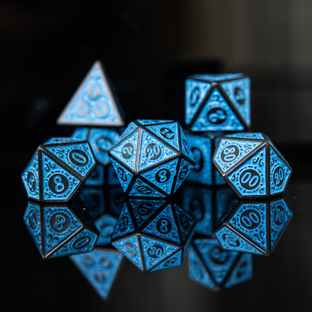 A set of blue acrylic ttrpg dnd dice with engraved numbers, displayed on a reflective surface