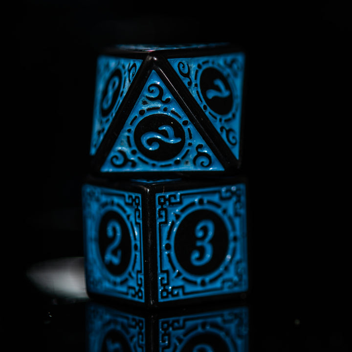 A set of blue acrylic ttrpg dnd dice with engraved numbers, displayed on a reflective surface