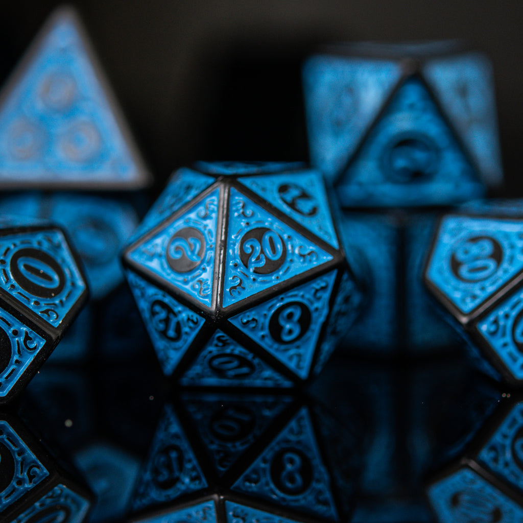 A set of blue acrylic ttrpg dnd dice with engraved numbers, displayed on a reflective surface