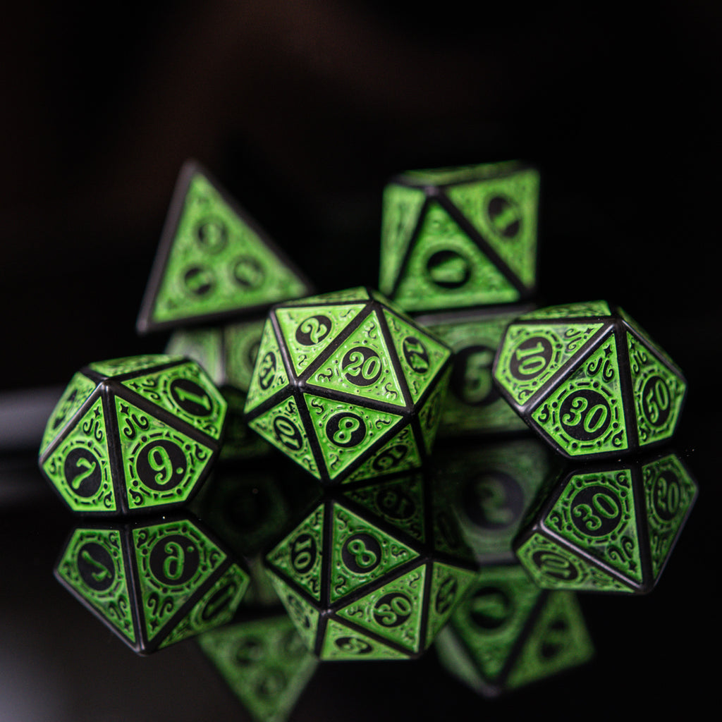 A set of green acrylic ttrpg dice with black engraved numbers, details and borders for tabletop gaming and board games