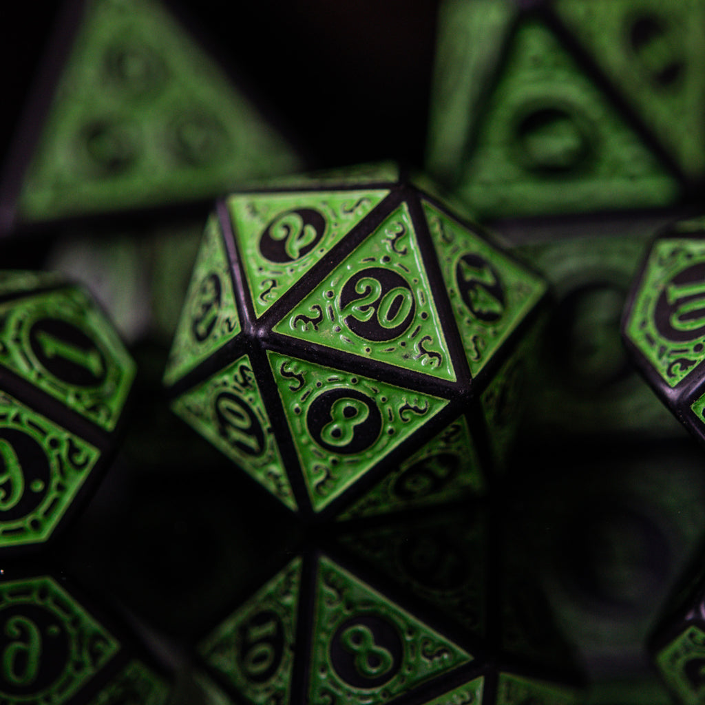 A set of green acrylic ttrpg dice with black engraved numbers, details and borders for tabletop gaming and board games