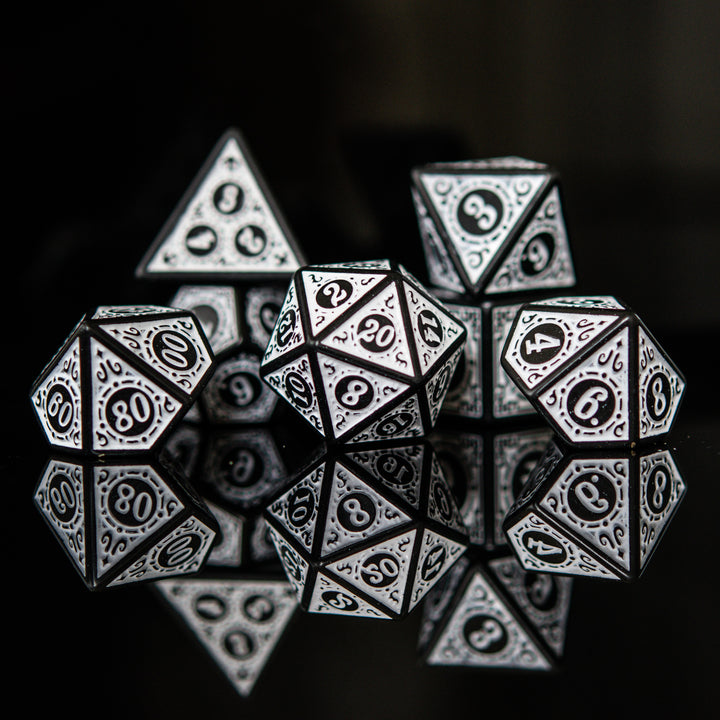 A set of white acrylic ttrpg dice with black engravings, displayed on a reflective surface.