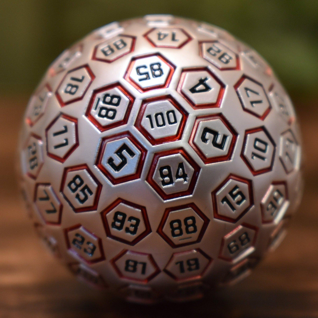 A red and matte silver metal D100 dice with engraved numbers on each face, displayed on a wooden surface.