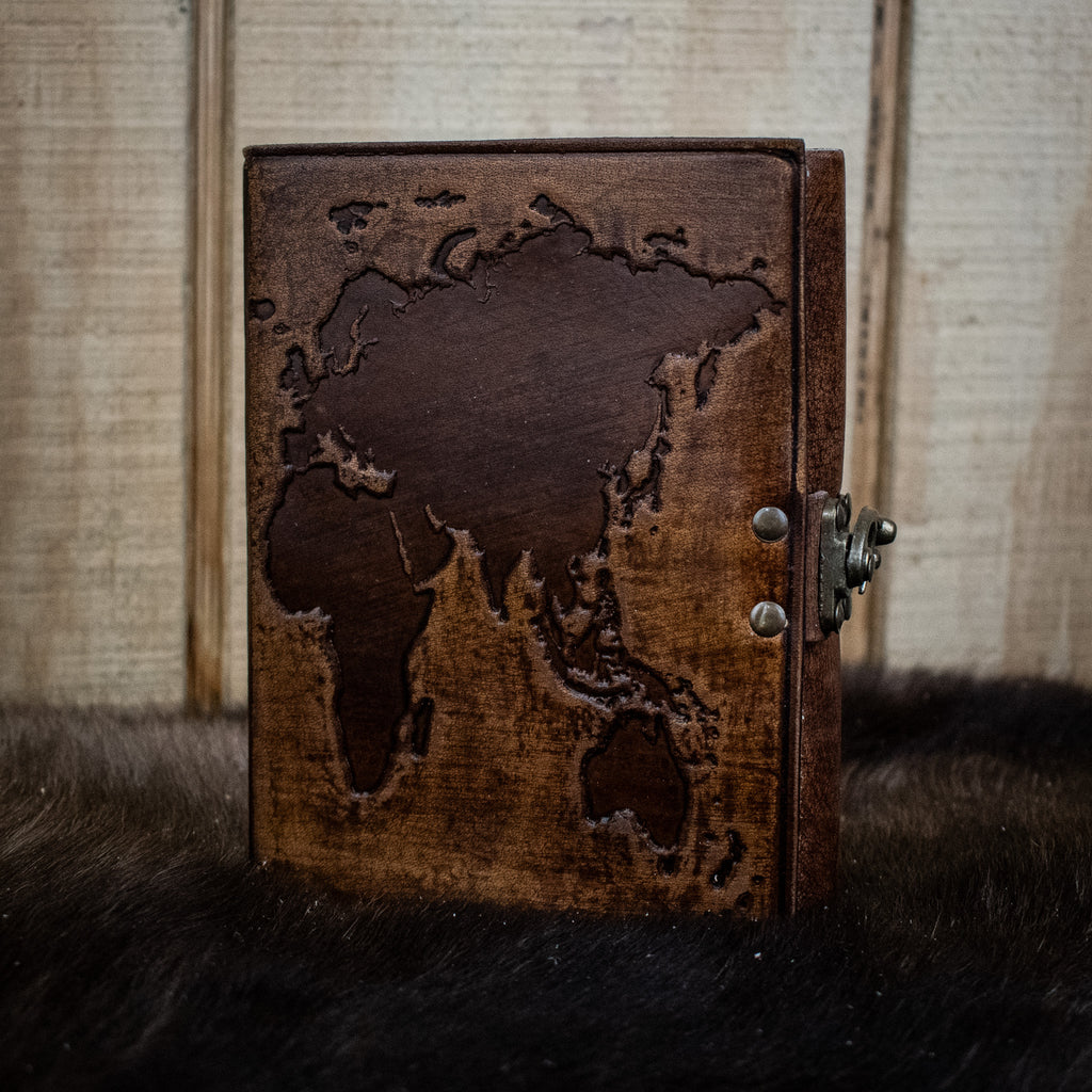 A dark brown leather journal featuring the world map