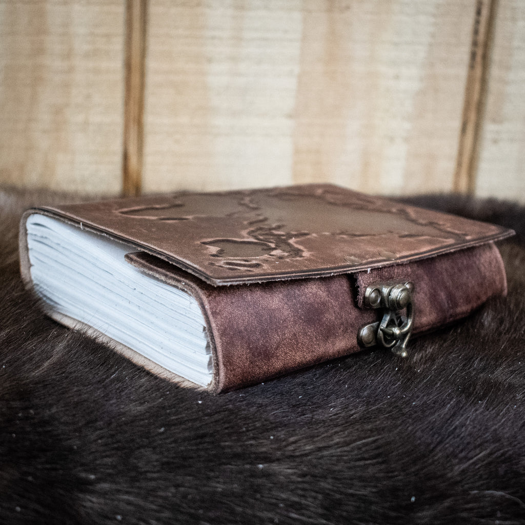 A dark brown leather journal featuring the world map