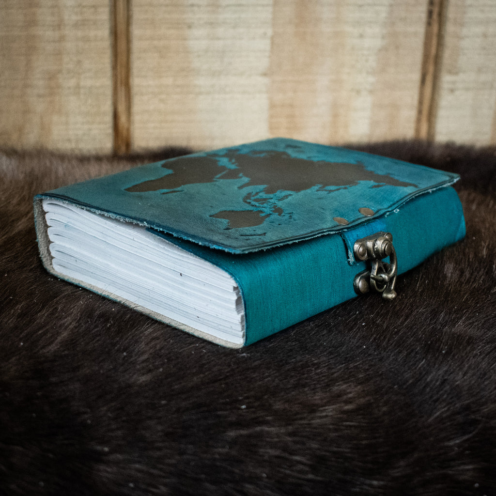 A blue leather journal featuring the world map