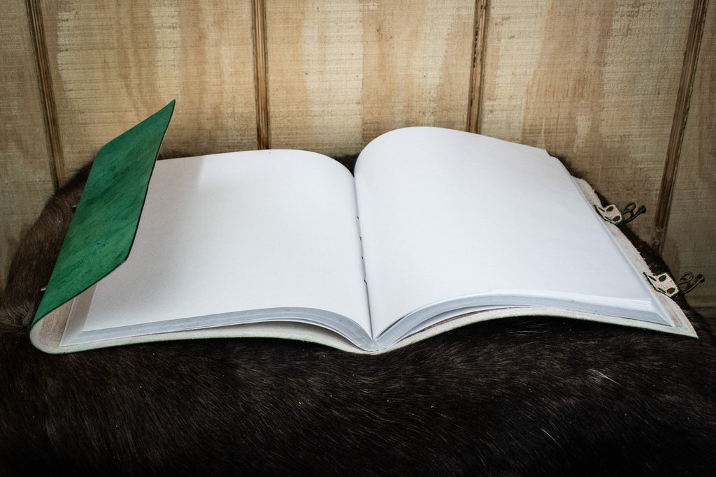 A green leather sketchbook featuring the tree of life