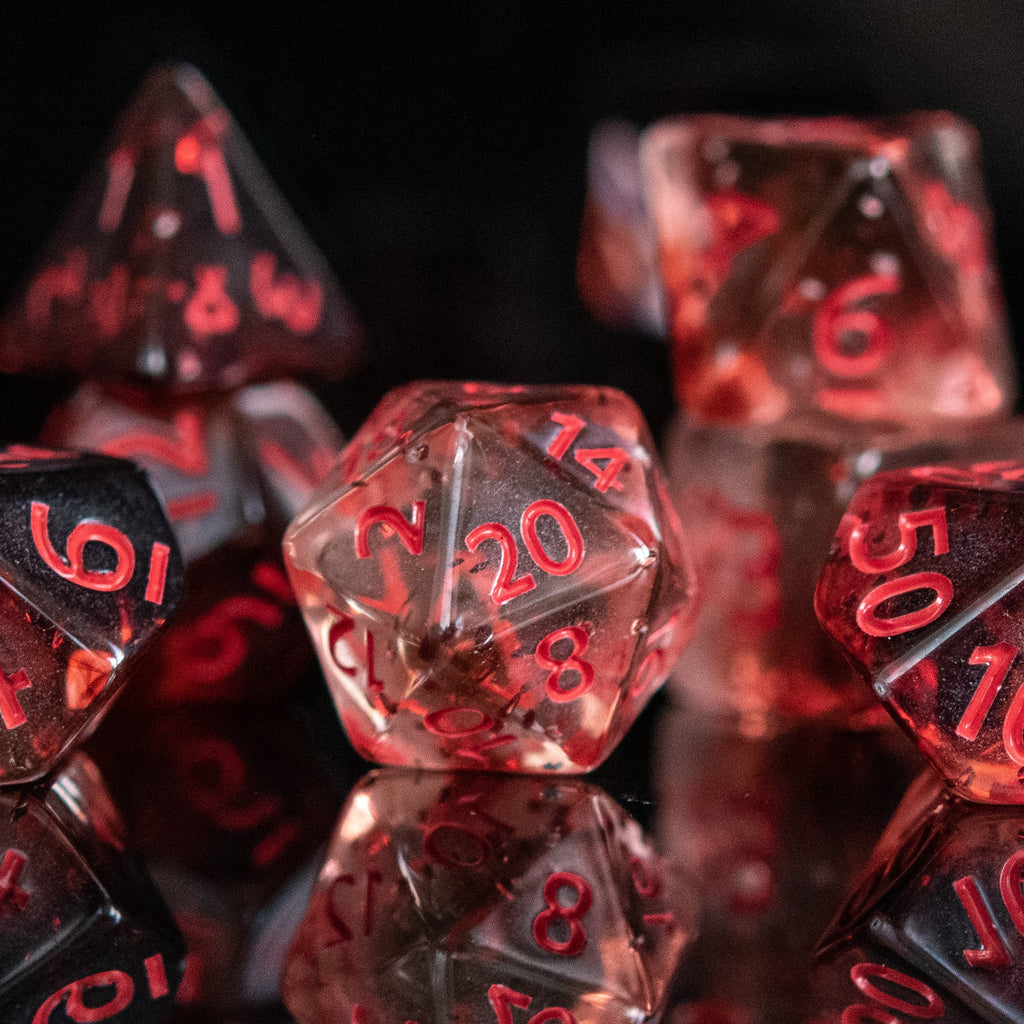 A set of acrylic dice with red numbers, including various shapes typical for role-playing games like a d4, d6, d8, d10, d12, and d20, displayed on a reflective surface.