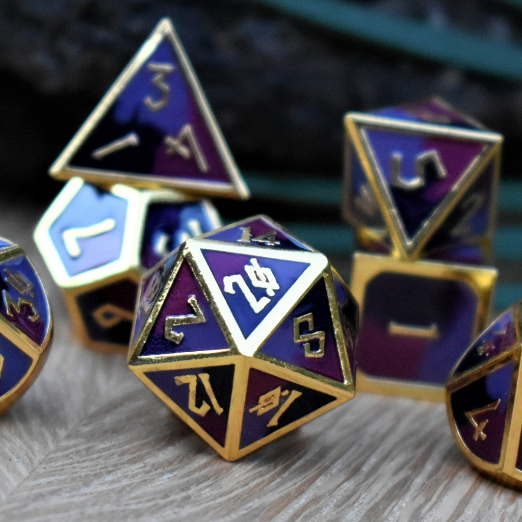 A set of metal dice that are different hues of purple with gold numbers and border for tabletop gaming and board games