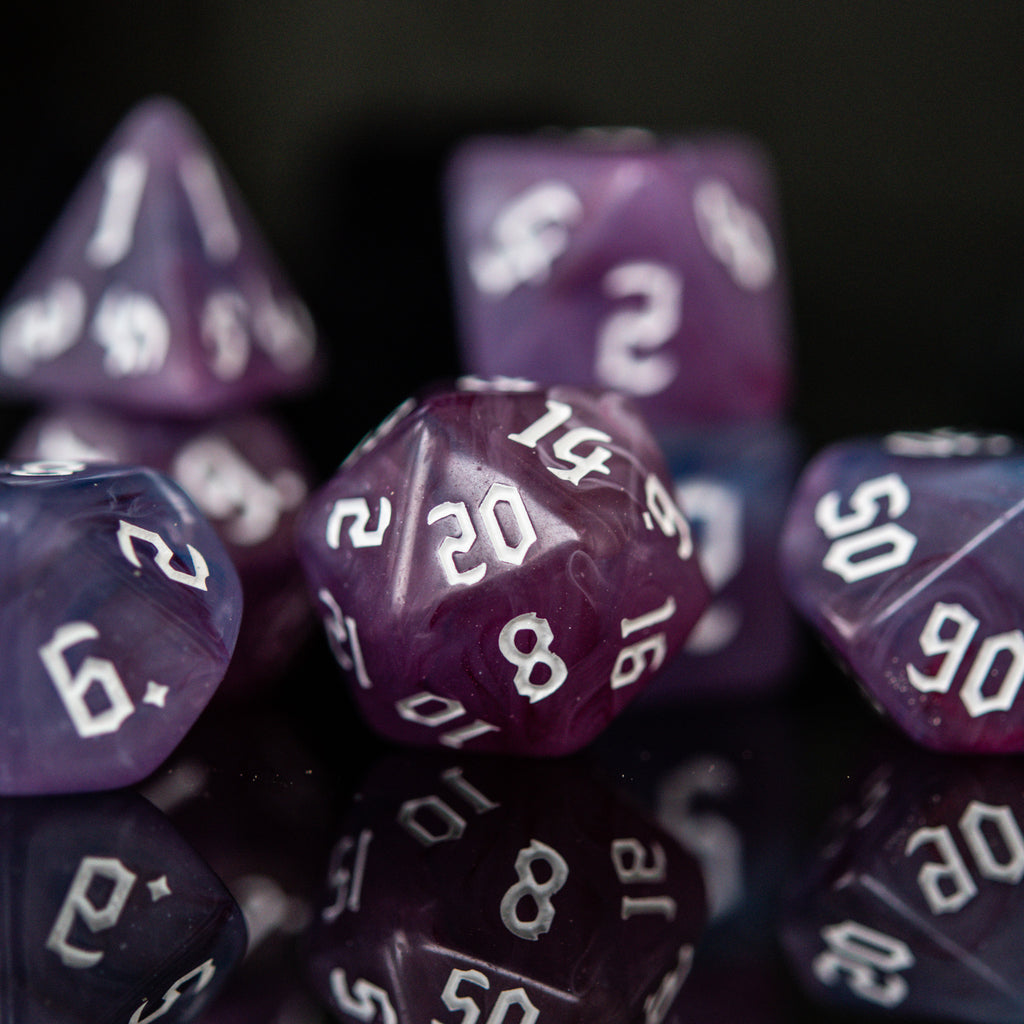 A set of purple shades of acrylic dice with engraved white numbers 