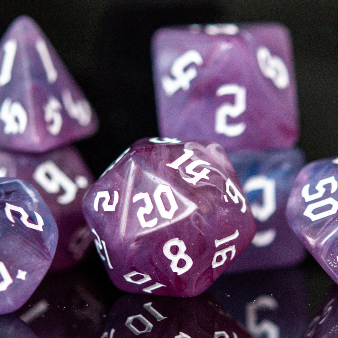 A set of purple shades of acrylic dice with engraved white numbers 
