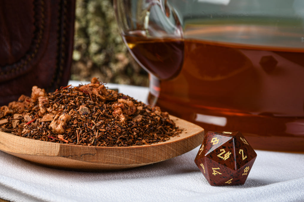 Tea package labeled 'Wild Wood Brew' by Misty Mountain Gaming on a wooden surface with a blurred green background.