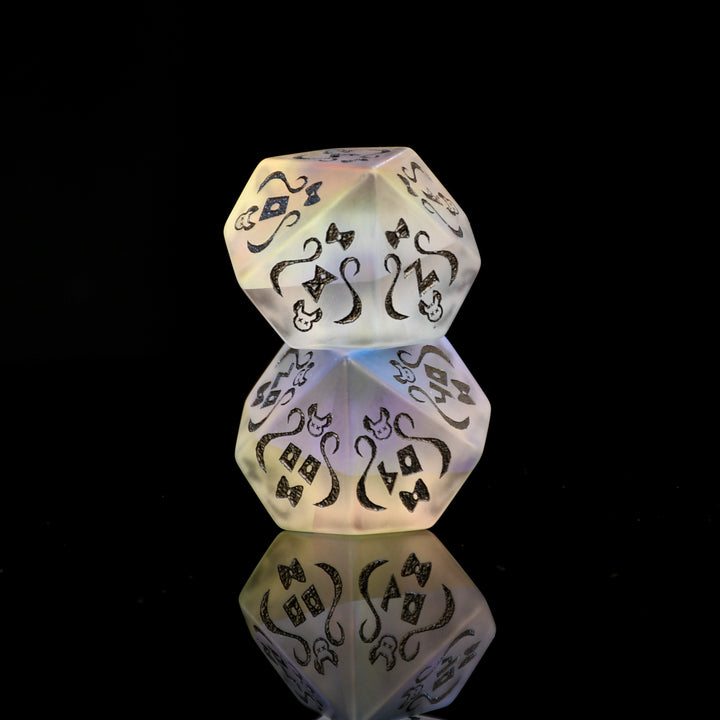 Decorative die with intricate black patterns on a reflective black surface