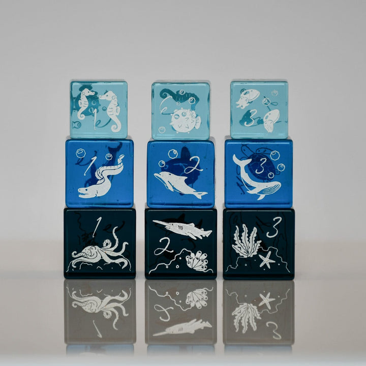 Set of colorful blocks with ocean-themed illustrations on a reflective surface.