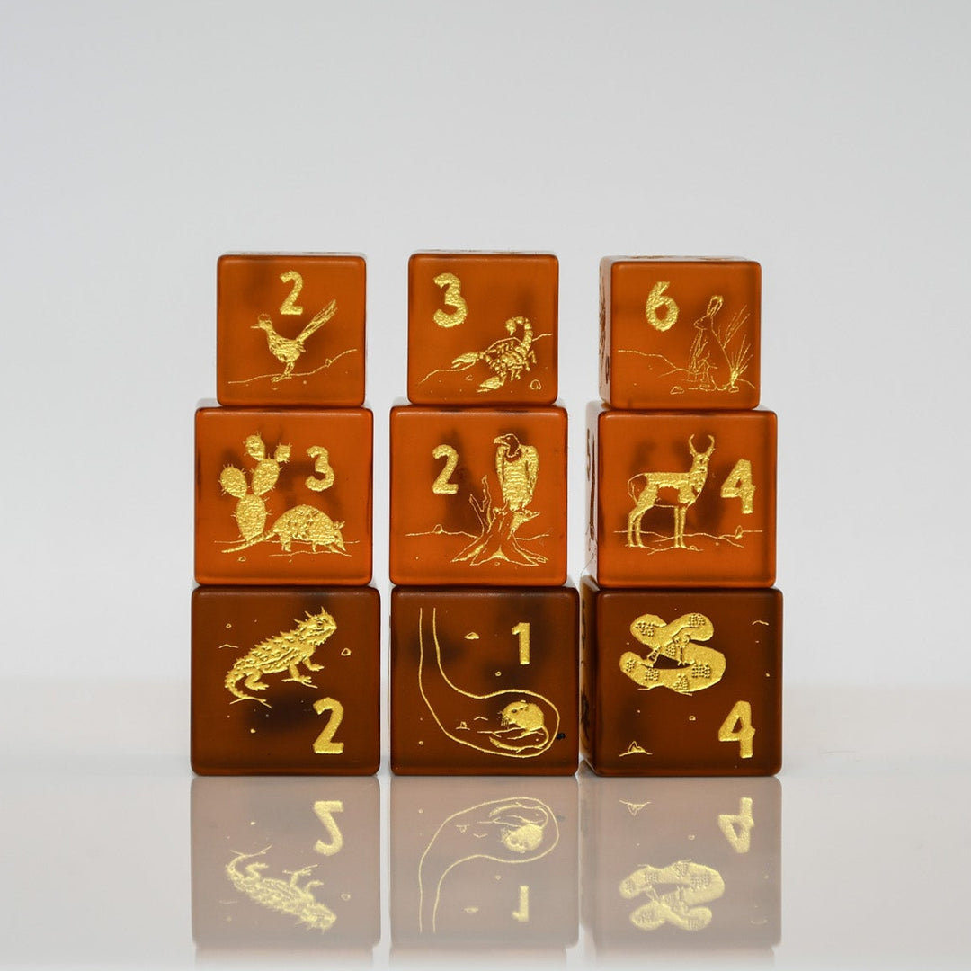 Set of brown dice with gold embossed numbers and symbols on a white background