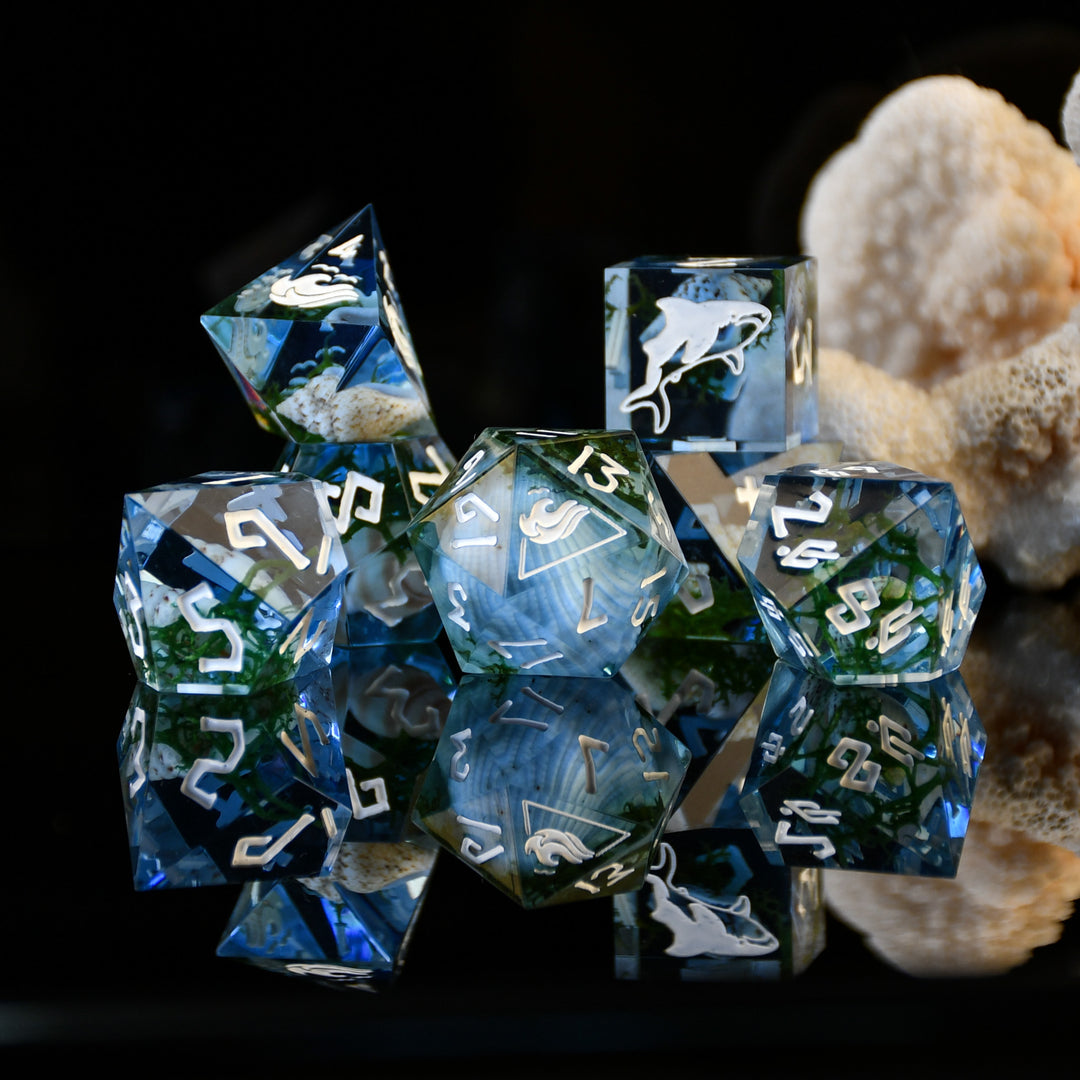 Set of blue and silver polyhedral dice with white numbers on a dark background
