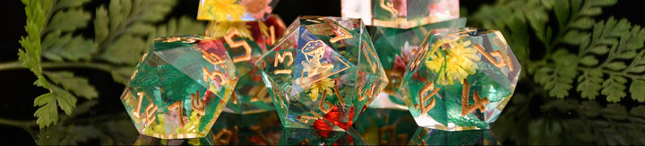 Set of colorful transparent dice with embedded figurines on a dark background with green leaves.