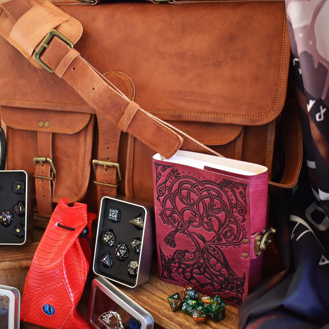 Leather laptop bag, dice sets, and other examples of items within the mystery bag bundle