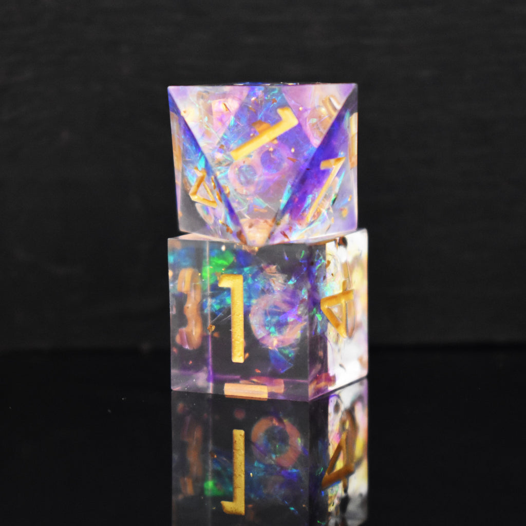A set of clear sharp edge resin dnd dice with gold numbering and pastel neon iridescent foil inside for tabletop games and board games