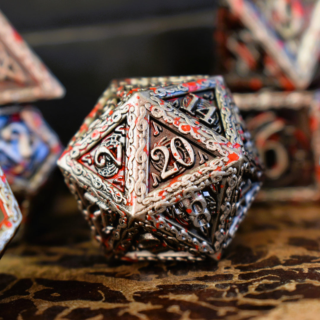 A set of silver metal dice with musical note details around the silver numbers splattered in red blood on a wooden surface, including various shapes such as a d4, d6, d8, d10, d12, and d20.